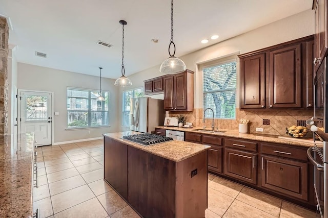 kitchen featuring appliances with stainless steel finishes, hanging light fixtures, sink, and a wealth of natural light