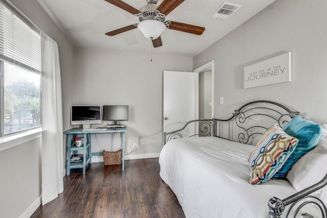 bedroom featuring dark wood-type flooring, ceiling fan, and a textured ceiling