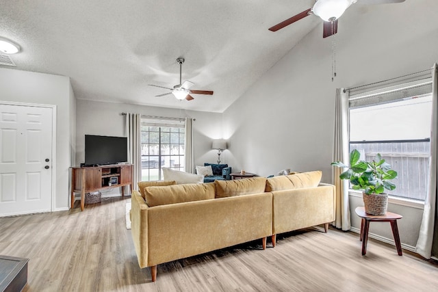 living room with high vaulted ceiling, ceiling fan, a textured ceiling, and light hardwood / wood-style floors