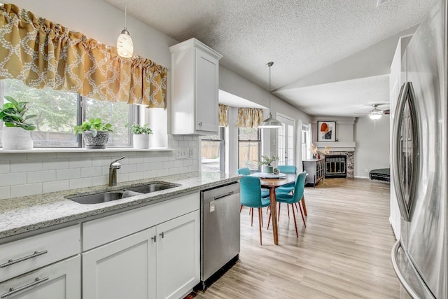 kitchen with white cabinets, appliances with stainless steel finishes, sink, and plenty of natural light