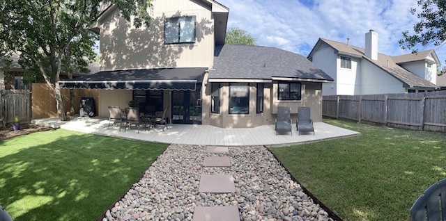 back of house featuring a lawn and a patio