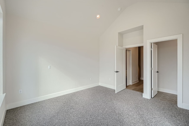 unfurnished bedroom featuring carpet flooring and vaulted ceiling