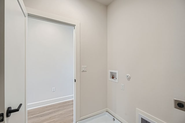 washroom with light wood-type flooring, electric dryer hookup, hookup for a washing machine, and hookup for a gas dryer