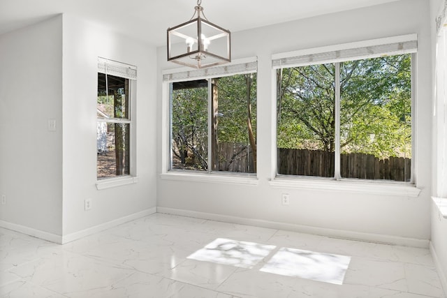 unfurnished sunroom featuring a wealth of natural light and a chandelier