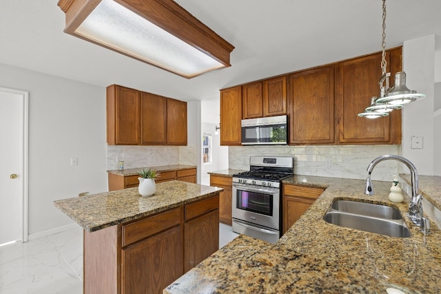 kitchen featuring pendant lighting, sink, decorative backsplash, and appliances with stainless steel finishes