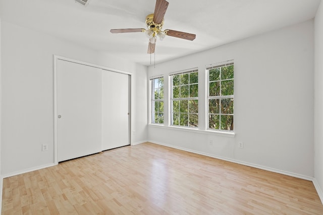 unfurnished bedroom with light hardwood / wood-style floors, ceiling fan, and a closet