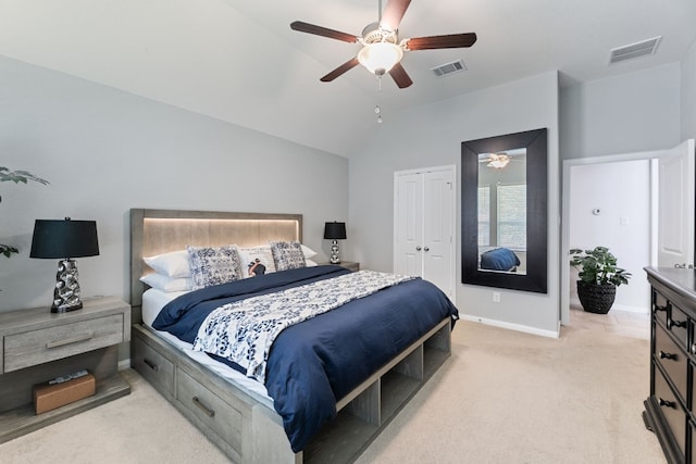 bedroom with ceiling fan, a closet, vaulted ceiling, and light colored carpet