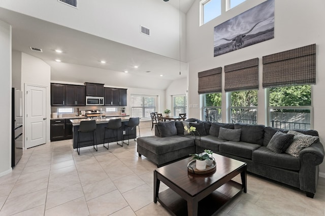 tiled living room featuring high vaulted ceiling