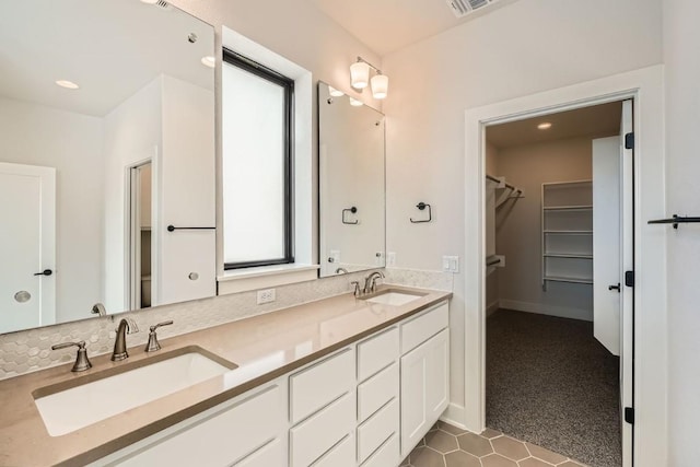 9027 Cattle Baron Path, Austin, TX 78747 - full bath featuring double vanity, a walk in closet, recessed lighting, and tile patterned flooring
