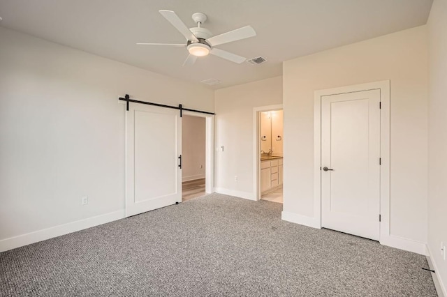 9027 Cattle Baron Path, Austin, TX 78747 - unfurnished bedroom with light colored carpet, a barn door, ensuite bath, and ceiling fan