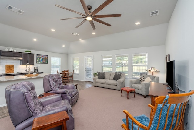 living room with high vaulted ceiling, ceiling fan, light wood-type flooring, and a wealth of natural light