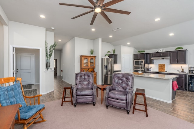 interior space with beverage cooler, light hardwood / wood-style floors, ceiling fan, and lofted ceiling