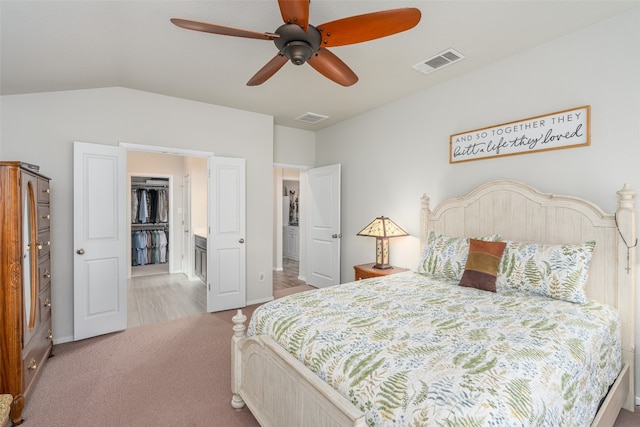 bedroom with ceiling fan, light carpet, and vaulted ceiling