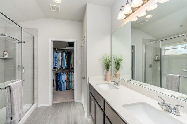 4303 Lindberg Ln, Lago Vista, TX 78645 - full bath with lofted ceiling, a shower stall, double vanity, a walk in closet, and baseboards