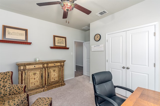 carpeted office space featuring ceiling fan