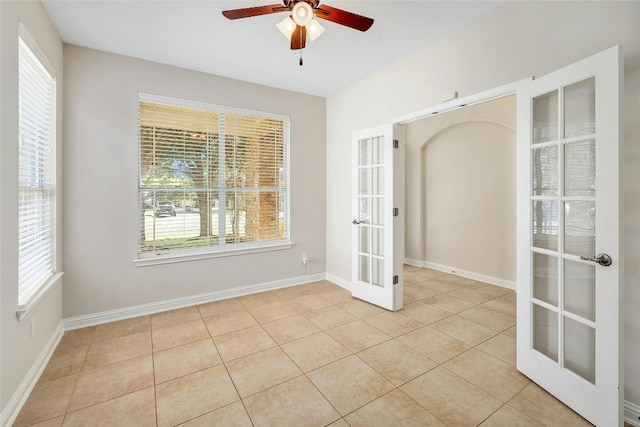 spare room with ceiling fan, french doors, and light tile patterned flooring