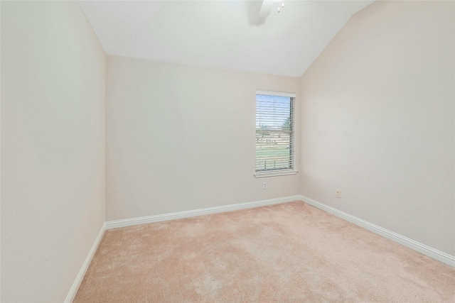 empty room featuring light colored carpet, ceiling fan, and vaulted ceiling