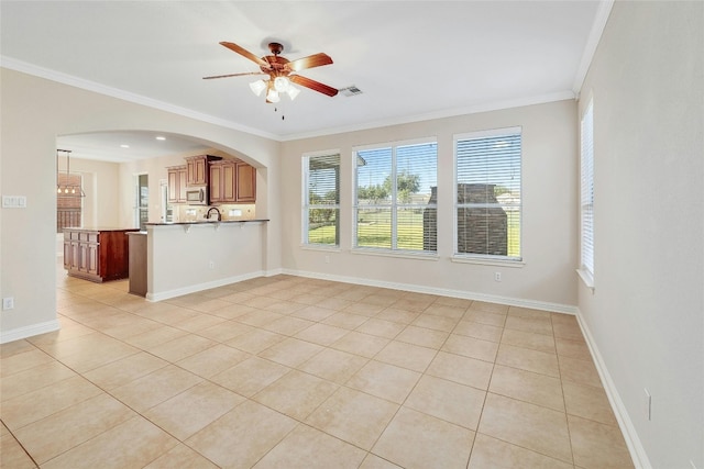 empty room featuring light tile patterned floors, crown molding, and ceiling fan