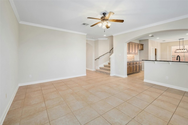 tiled spare room with ornamental molding, ceiling fan, and sink