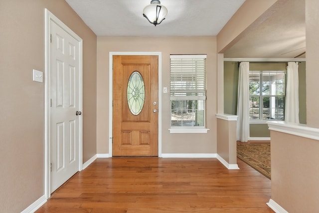 foyer entrance featuring light hardwood / wood-style floors and a textured ceiling