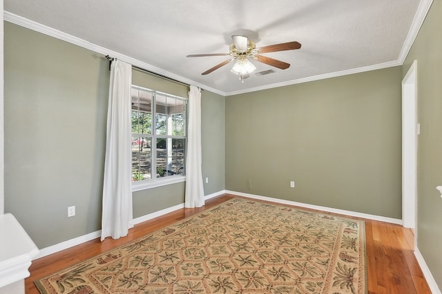 unfurnished room with hardwood / wood-style floors, ceiling fan, and crown molding