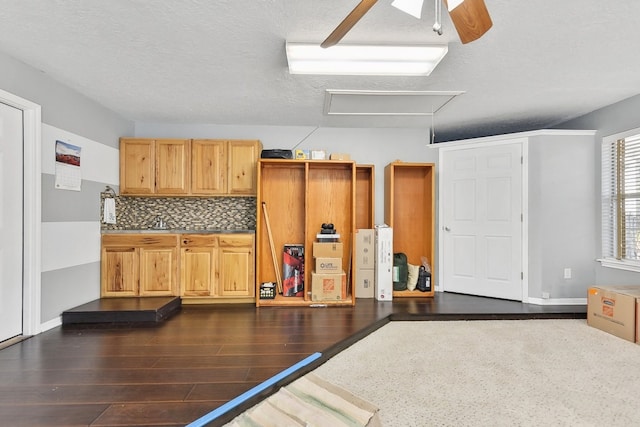 exercise area featuring dark wood-type flooring, a textured ceiling, and ceiling fan