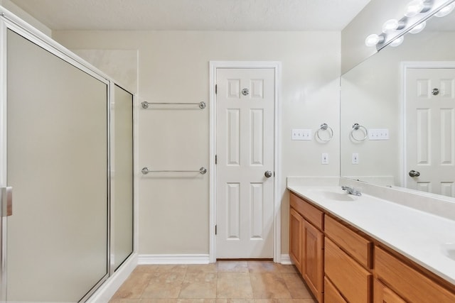 bathroom with a shower with door, vanity, tile patterned flooring, and a textured ceiling