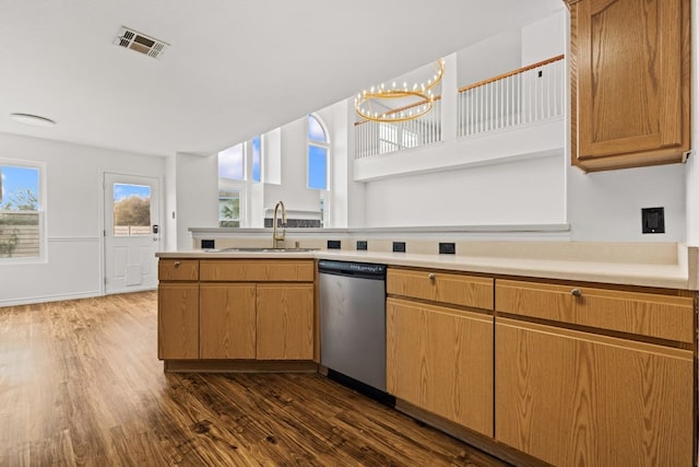 kitchen featuring dark wood-type flooring, an inviting chandelier, stainless steel dishwasher, and sink