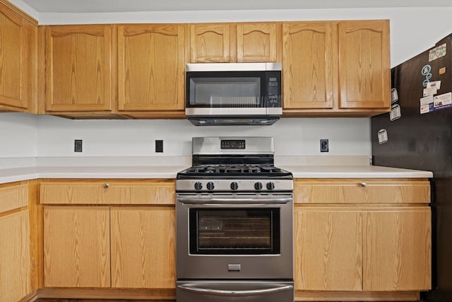 kitchen featuring light brown cabinetry and appliances with stainless steel finishes