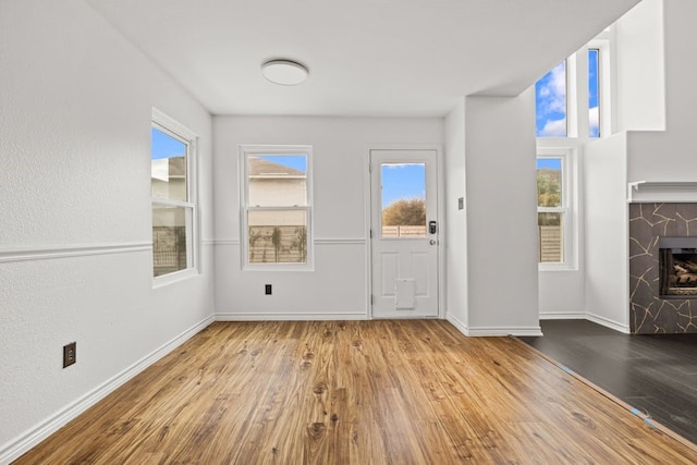 foyer with light hardwood / wood-style floors and a fireplace