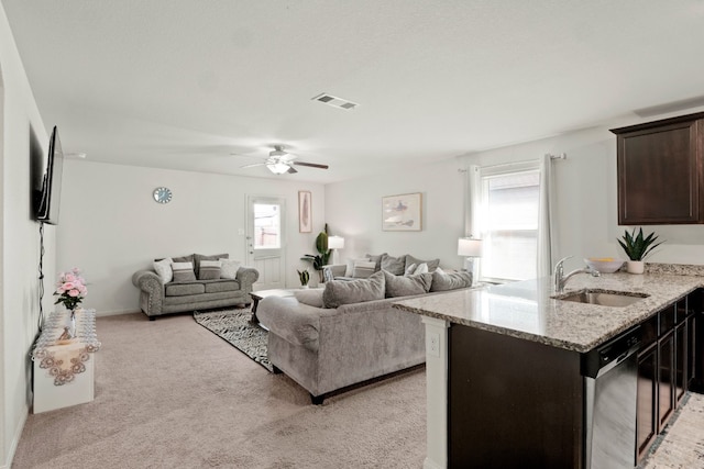 living room with sink, light colored carpet, and ceiling fan