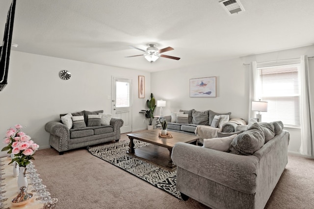 living room featuring carpet flooring, a textured ceiling, and ceiling fan