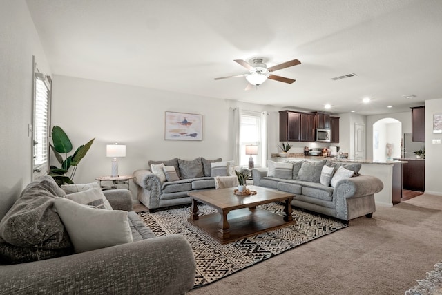 carpeted living room featuring ceiling fan