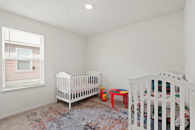 carpeted bedroom with a nursery area