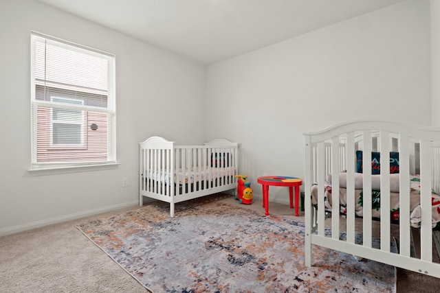 bedroom with a nursery area and carpet floors