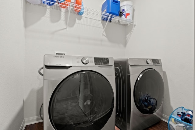 clothes washing area featuring dark hardwood / wood-style floors and washer and dryer