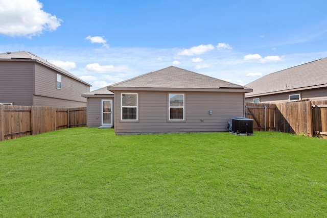 back of house featuring central air condition unit and a yard