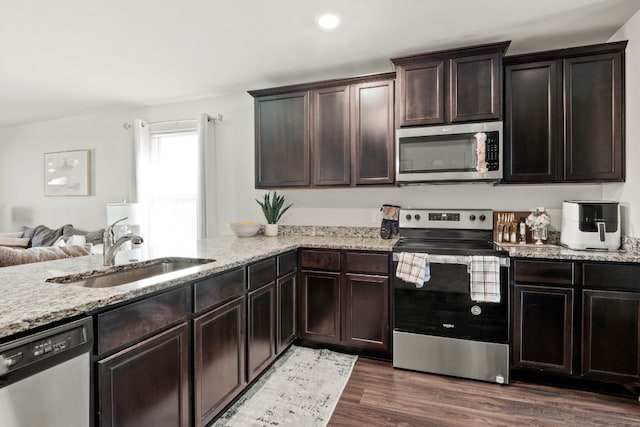 kitchen with dark brown cabinetry, dark hardwood / wood-style flooring, sink, and appliances with stainless steel finishes