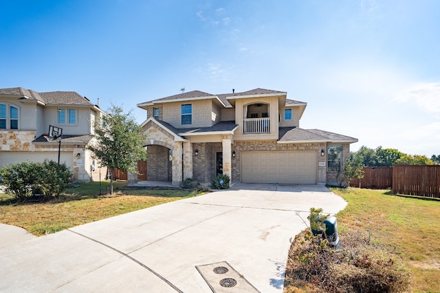 view of front of property featuring a balcony, a front yard, and a garage