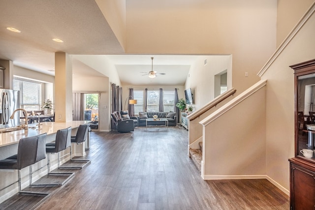 foyer with dark wood-type flooring, ceiling fan, sink, and vaulted ceiling