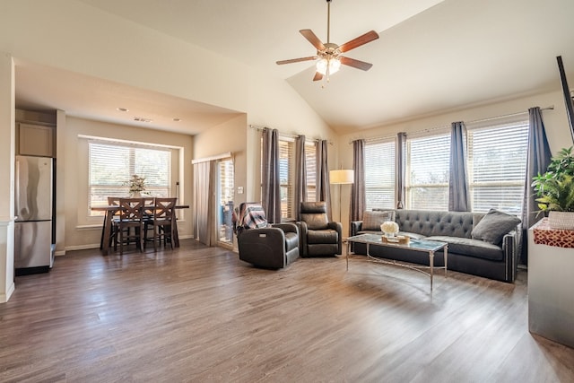 living room with dark wood-type flooring, ceiling fan, and high vaulted ceiling