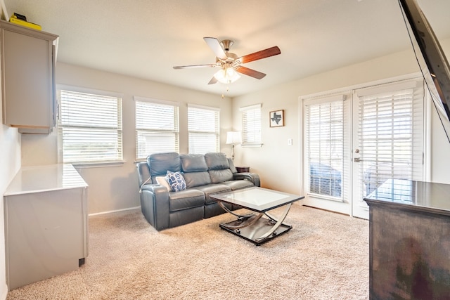 living room with plenty of natural light, light carpet, and ceiling fan