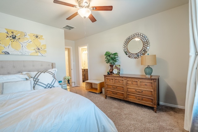 bedroom with ensuite bathroom, ceiling fan, and light colored carpet