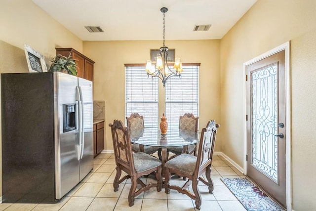 tiled dining space with a chandelier