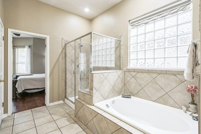 bathroom with separate shower and tub and tile patterned flooring