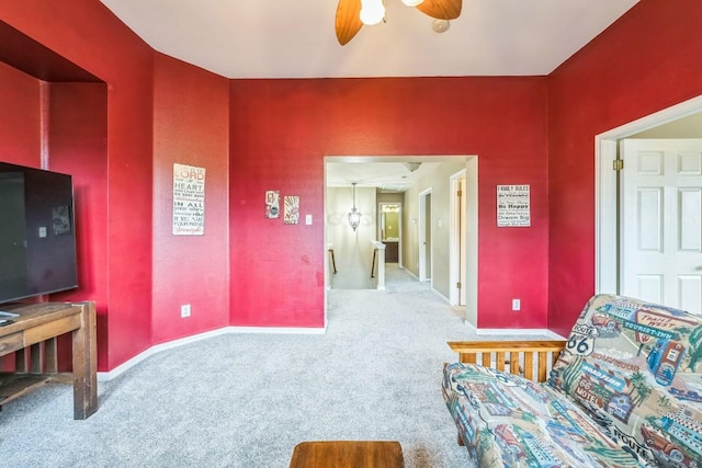 living area with carpet and ceiling fan