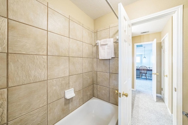 bathroom featuring tiled shower / bath