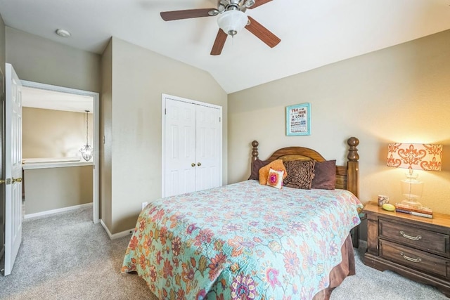 bedroom featuring vaulted ceiling, light colored carpet, ceiling fan, and a closet