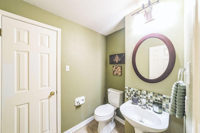 bathroom featuring tile patterned flooring, sink, a textured ceiling, and toilet