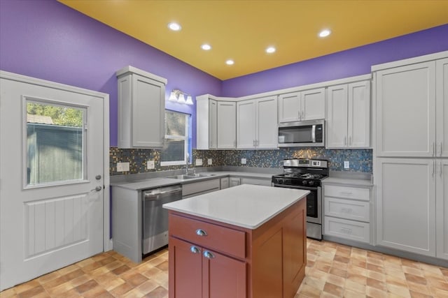 kitchen featuring tasteful backsplash, appliances with stainless steel finishes, sink, white cabinets, and a center island